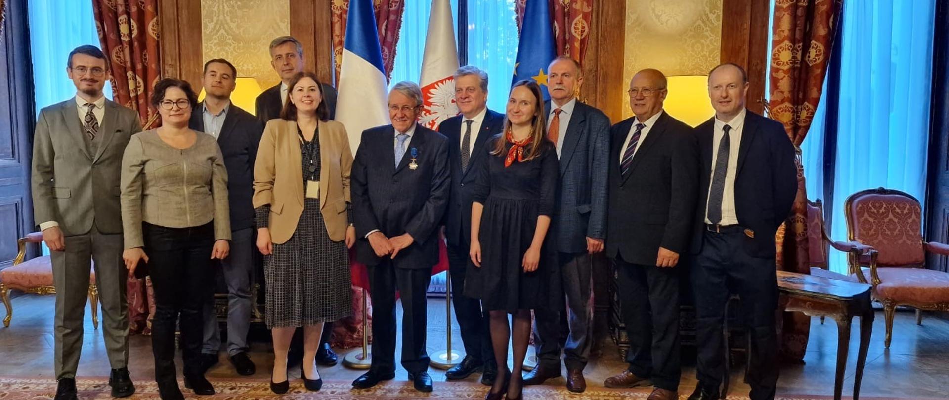 Grupa osób pozuje do zdjęcia, w centrum kadru mężczyzna Michel Dorin z przypiętym odznaczeniem.