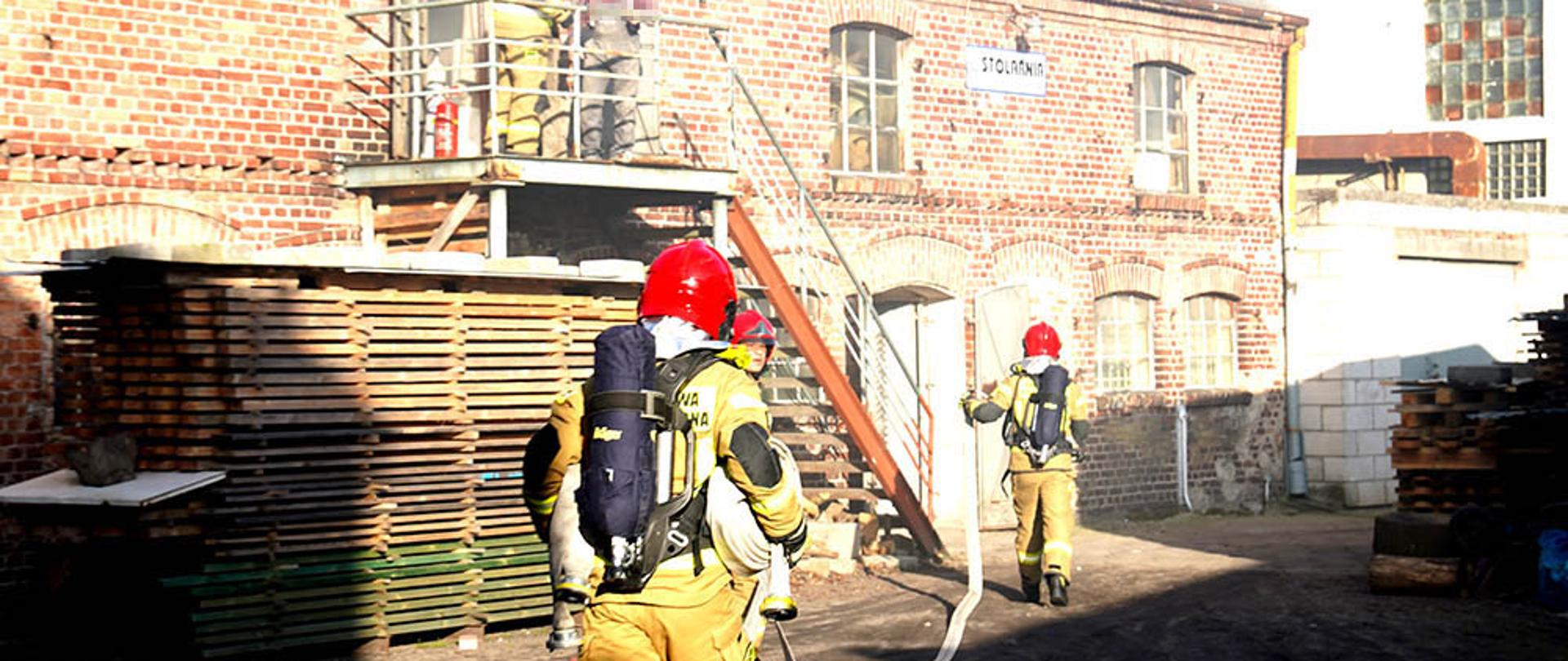 Działania strażaków przy gaszeniu stolarni.