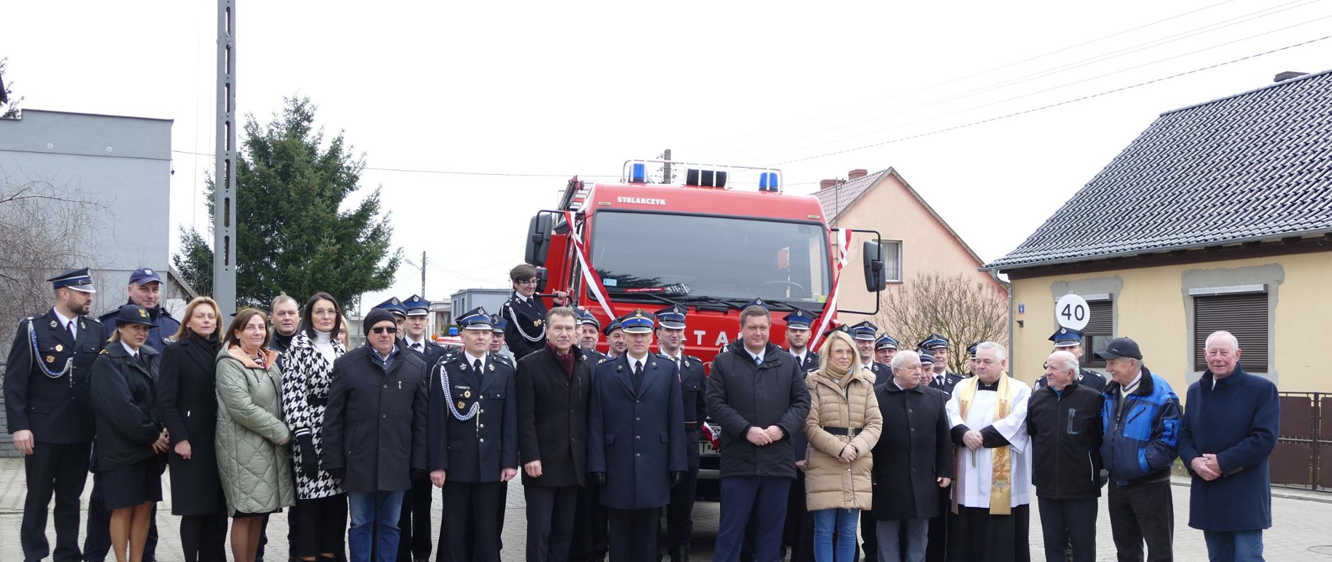 Wspólne zdjęcie wszystkich gości przy samochodzie pożarniczym