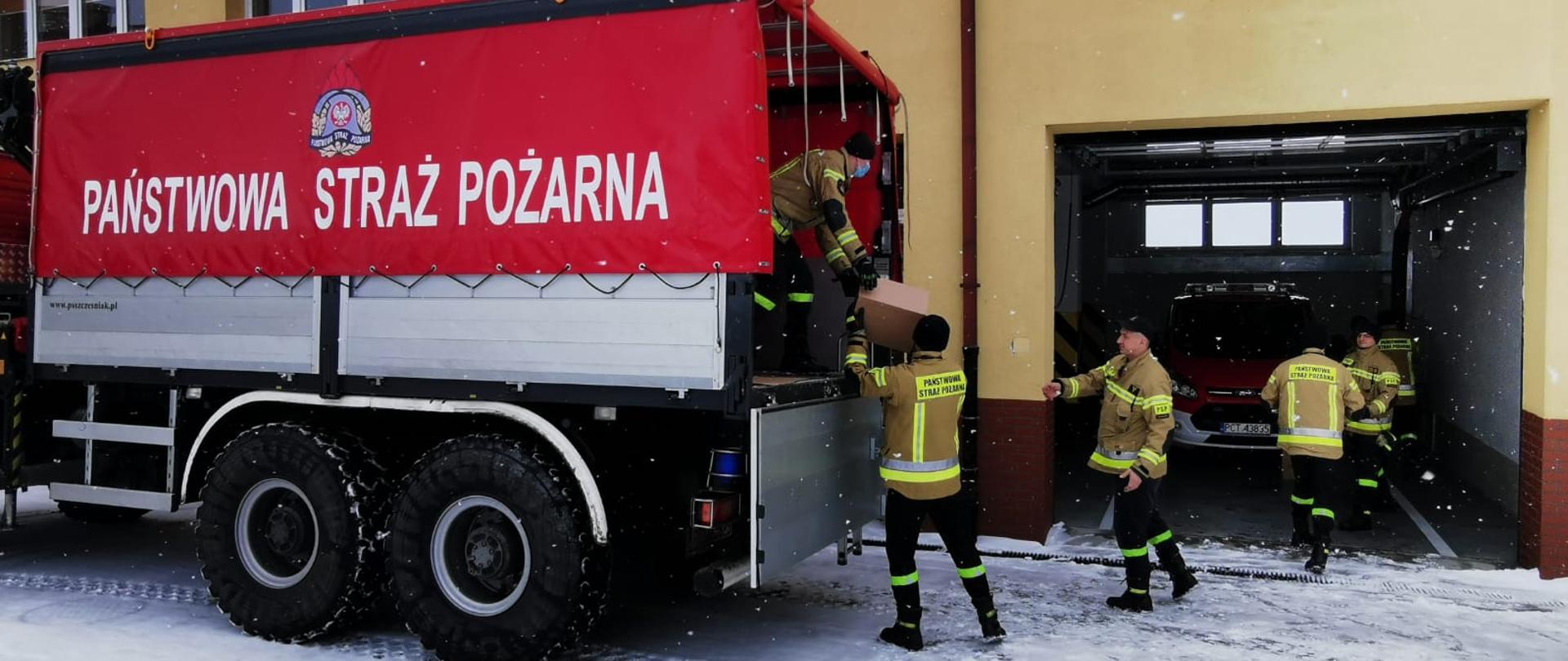 Rozładunek środków dezynfekujących przez strażakówc