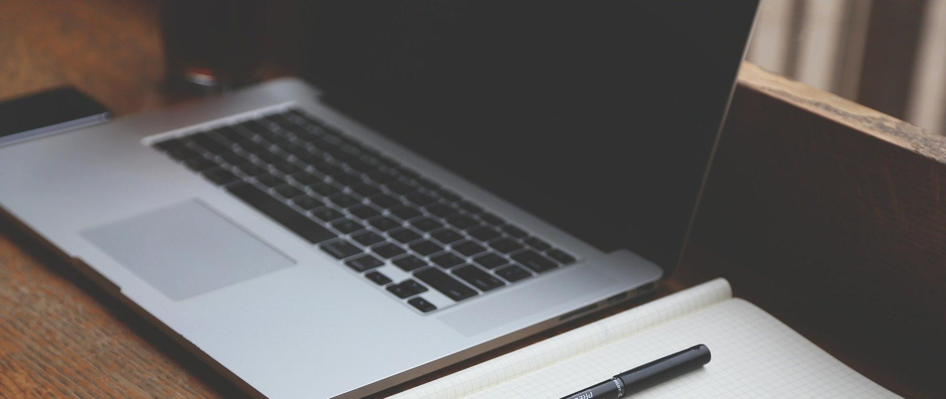 laptop z zeszytem na stoliku