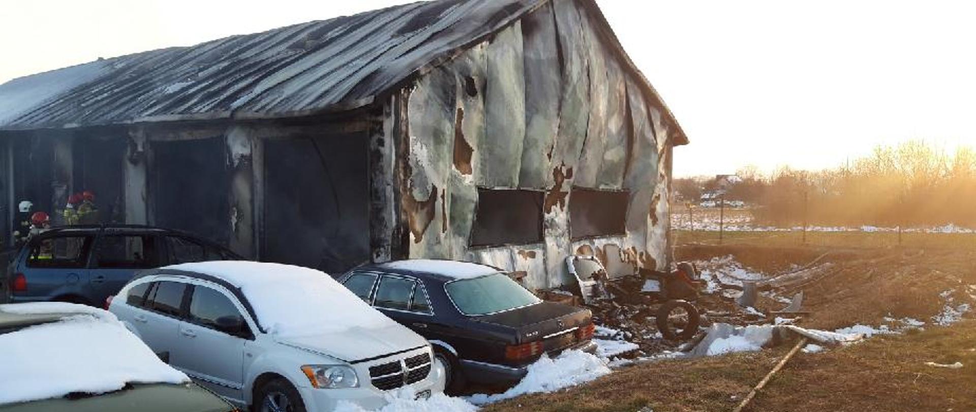 Fotografia przedstawia zniszczony przez ogień warsztat samochodowy. Pogięta blacha ścian świadczy o wysokiej temperaturze jaka na nią działała.