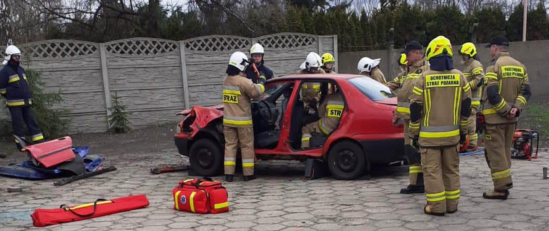 Na zdjęciu druhowie Ochotniczej Straży Pożarnej podczas ćwiczenia pracy z ratowniczymi narzędziami ratowniczymi.