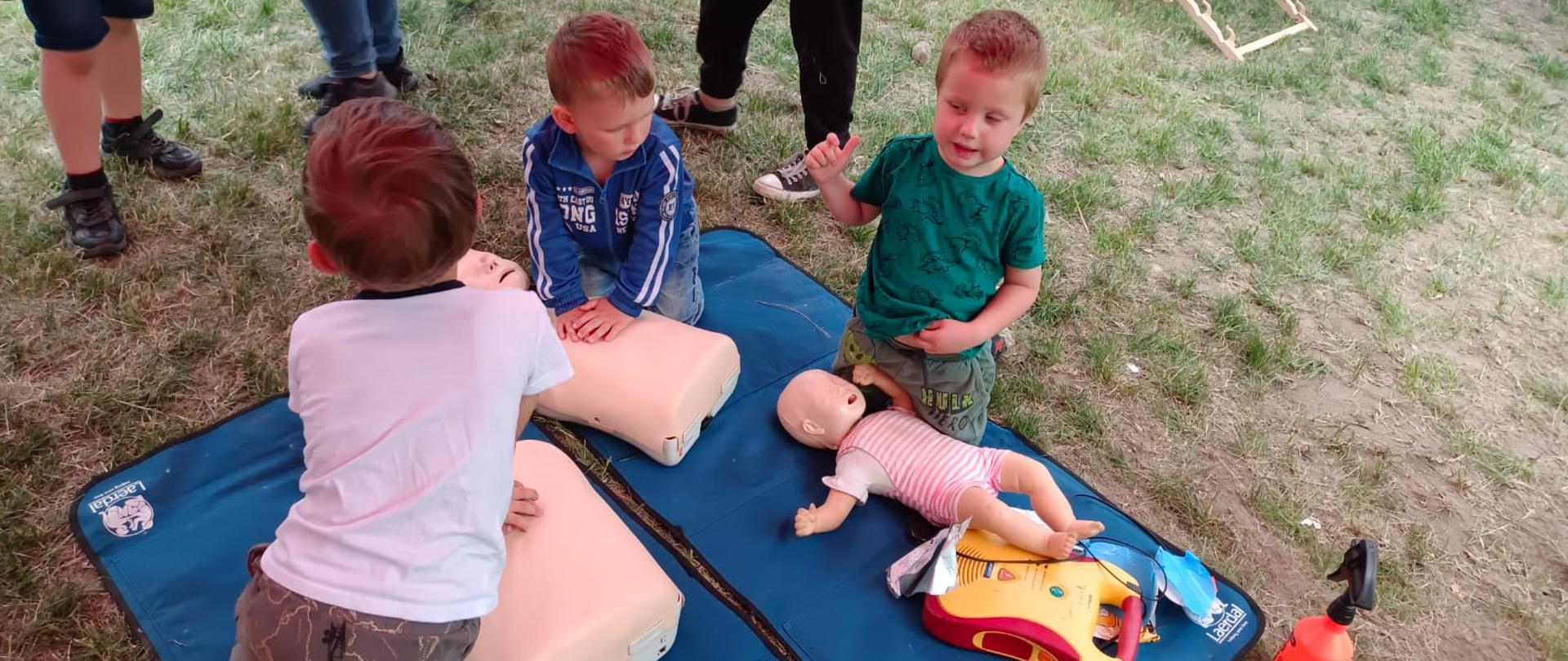 Widać dzieci podczas udzielania pierwszej pomocy na fantomach
