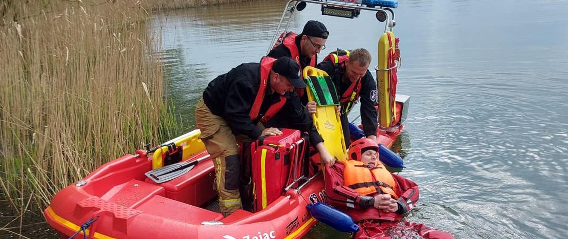 Podjęcie poszkodowanej osoby z łodzi ratowniczej. 