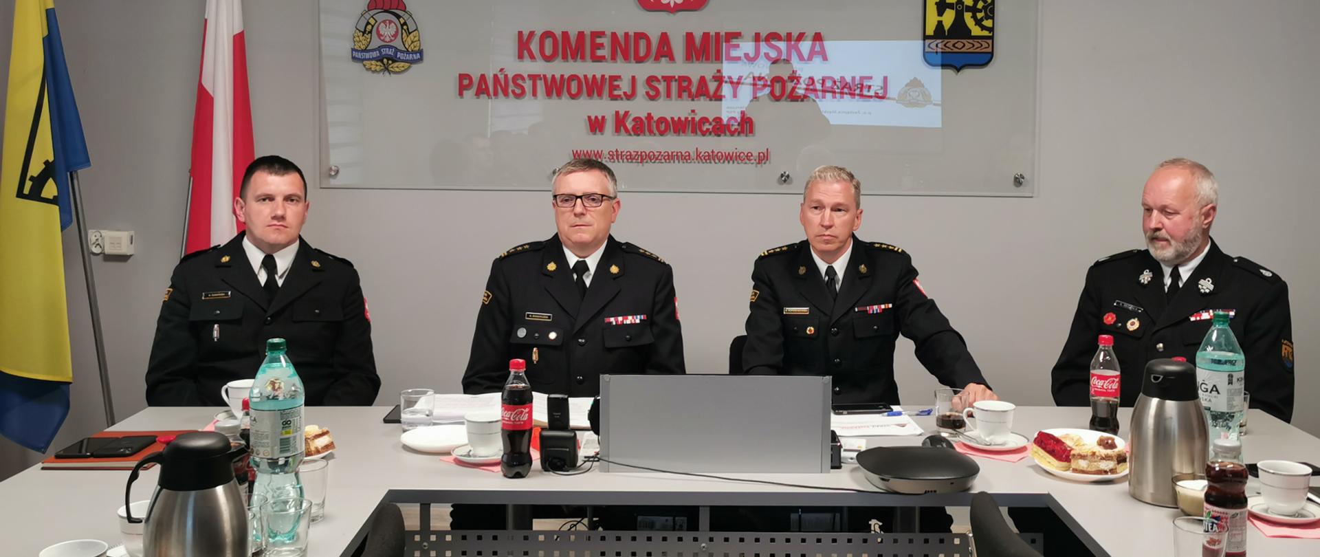 Przy stole siedzi Zastępca Śląskiego Komendanta Wojewódzkiego PSP st. bryg. Rafał Świerczek, Komendant Miejski PSP w Katowicach oraz dwóch funkcjonariuszy 