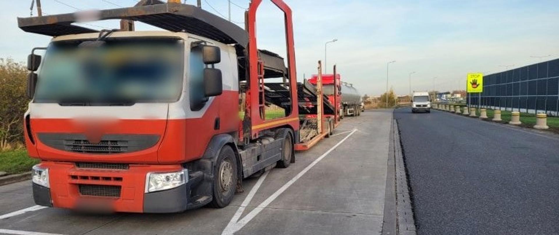 Na pierwszym planie (od lewej): samochód ciężarowy z podpiętą przyczepą do przewozu samochodów stoi w zatoce kontrolnej przy autostradzie A2. W tle: za kontrolowanym zespołem pojazdów stoi ciągnik siodłowy z podpiętą naczepą typu cysterna i oznakowany furgon mazowieckiej Inspekcji Transportu Drogowego.