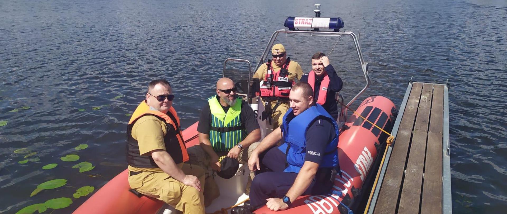 Funkcjonariusze siedzą na łodzi
