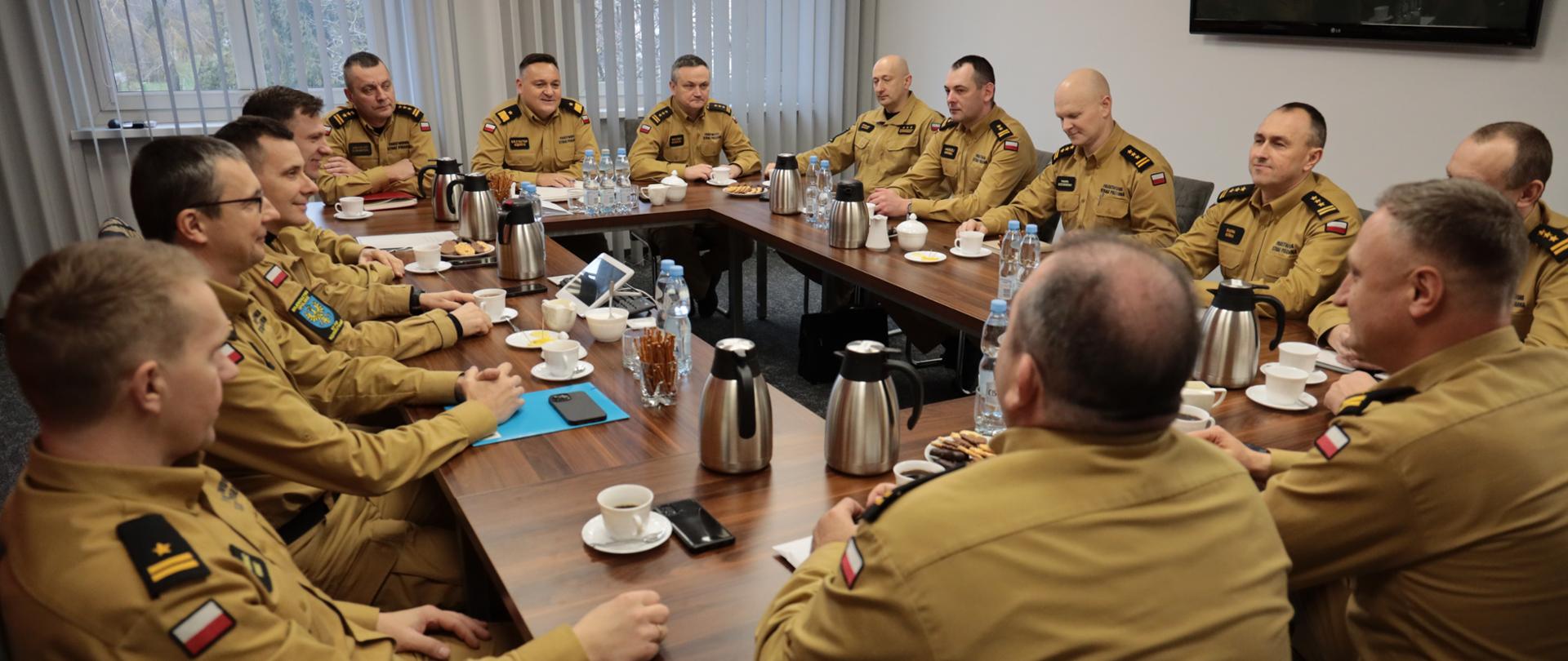 Na zdjęciu widać komendantów PSP woj. opolskiego w umundurowaniu służbowych zasiadających przy jednym stole, omawiających bieżące sprawy.