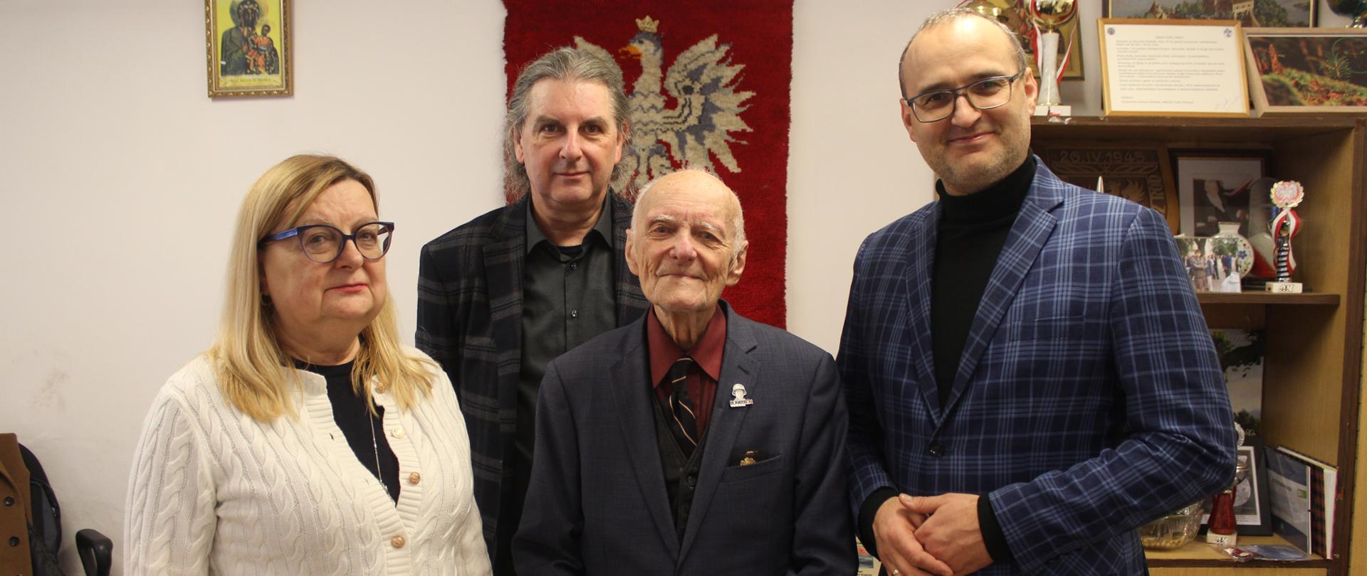 grupa osób stoi w pokoju i pozuje do zdjęcia