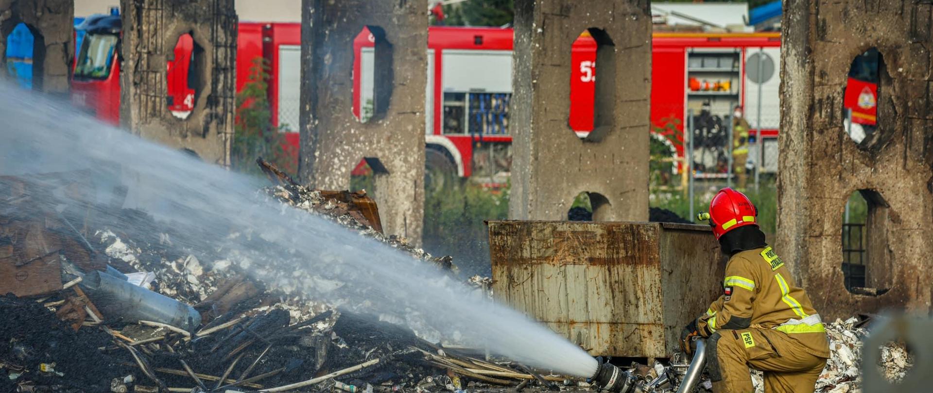 Strażak podaje prąd wody na pożar