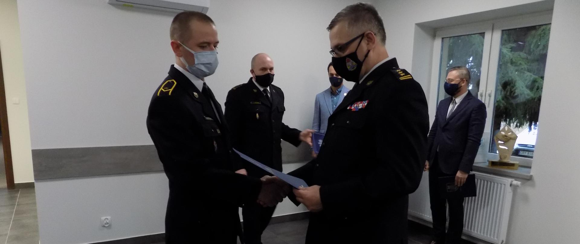 Kujawsko - pomorski komendant wojewódzki PSP st. bryg. Jacek Kaczmarek wręcza wyróżnienie mł. asp. R. Raczkowskiemu.