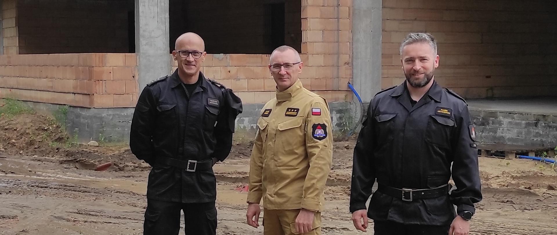 Na zdjęciu zastępca komendanta z kierownictwem komendy powiatowej PSP w Żarach przez budowanym budynkiem strażnicy.