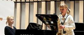 Laura Nowak gra na saksofonie. Akompaniuje jej przy fortepianie pani Elwira Janiec-Krajewska.