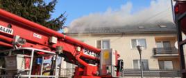 Na zdjęciu widoczny jest budynek mieszkalny z którego wydobywa się dym