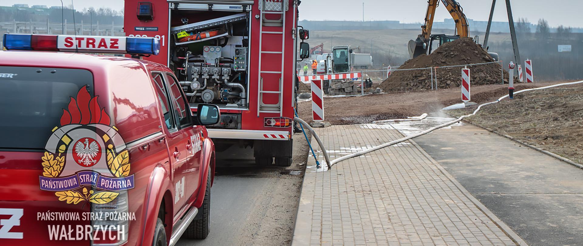 Na zdjęciu dwa wozy strażackie, w tle 2 koparki