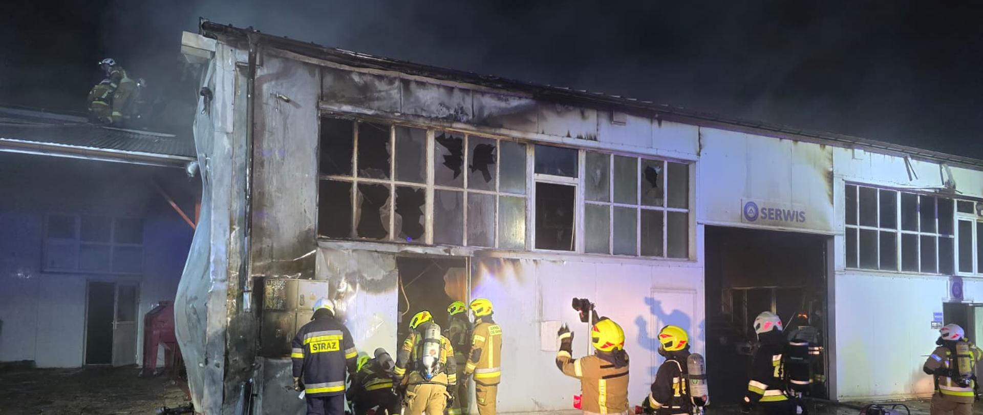 Na zdjęciu widać strażaków którzy walcząc z pożarem budynku gospodarczego.