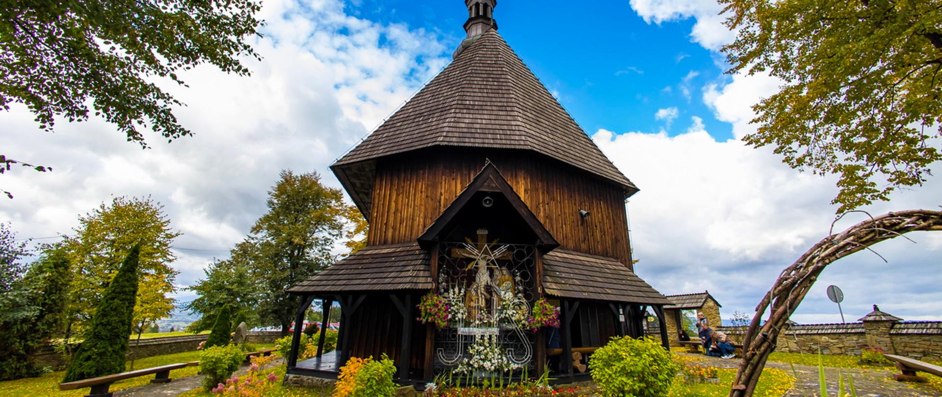 zdjęcie drewnianego kościółka w Rdzawce na tle nieba