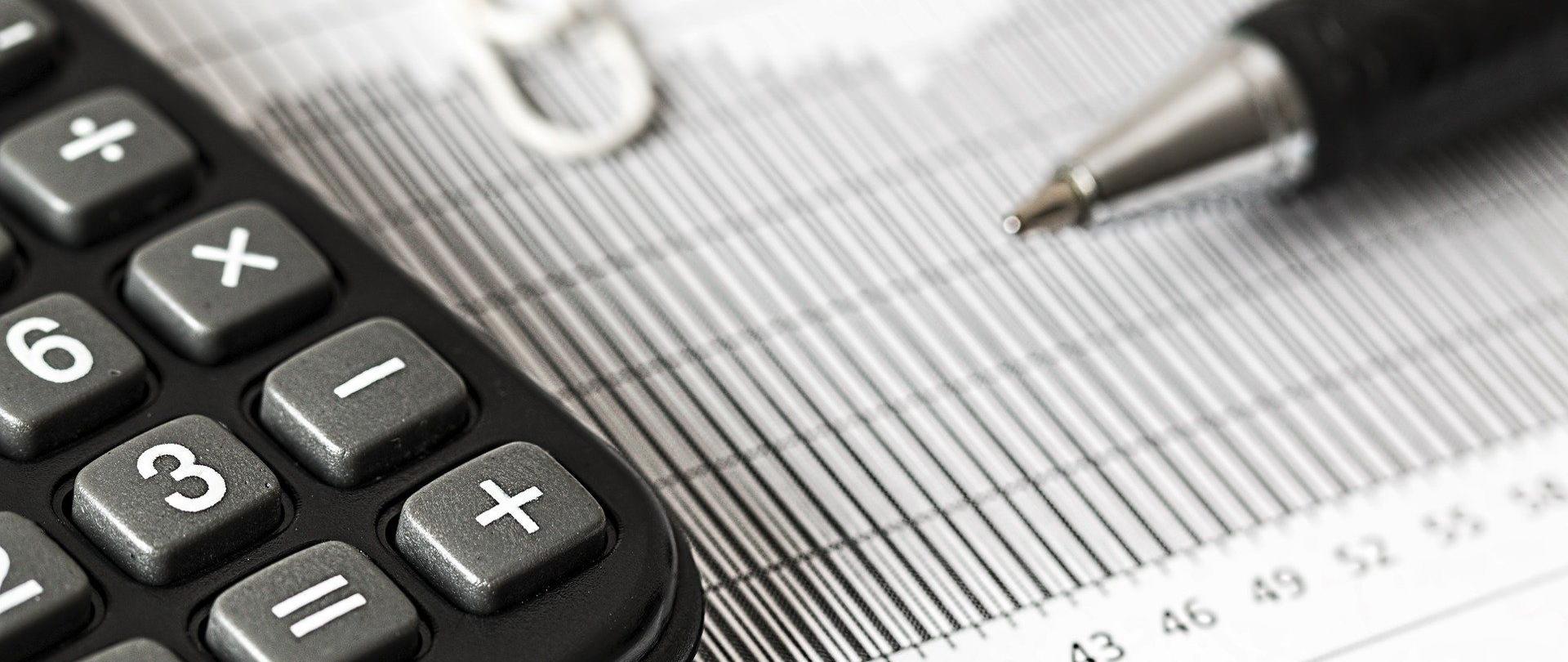 Kalkulator i długopis, tabela.