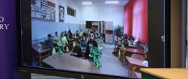 Monitor z obrazem transmitowanym na bieżąco z sali lekcyjnej szkoły podstawowej w Bełżycach.