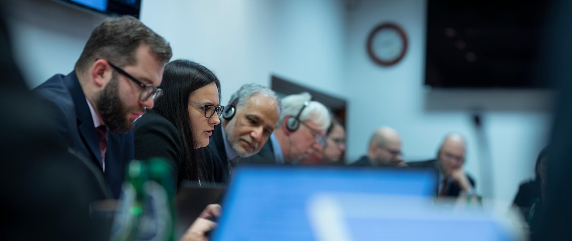 przy stole siedzą uczestnicy spotkania, do mikrofonu mówi minister Małgorzata Jarosińska-Jedynak