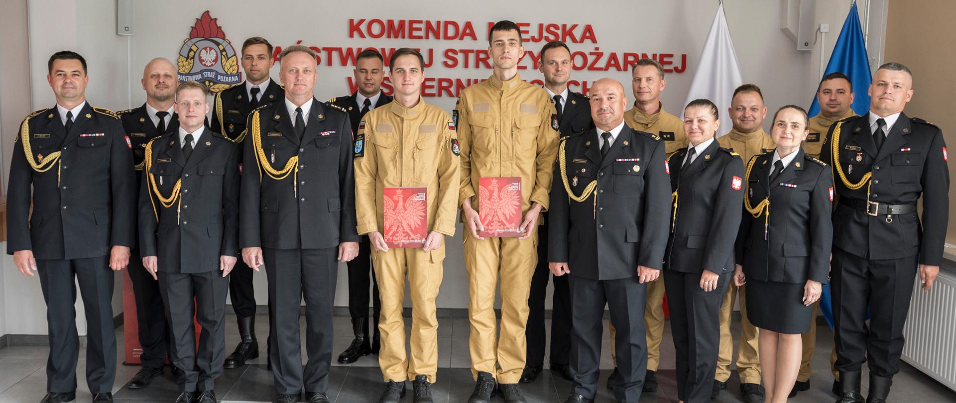Uczestnicy uroczystości ślubowania pozują do wspólnego zdjęcia w Komendzie Miejskiej PSP w Skierniewicach.
