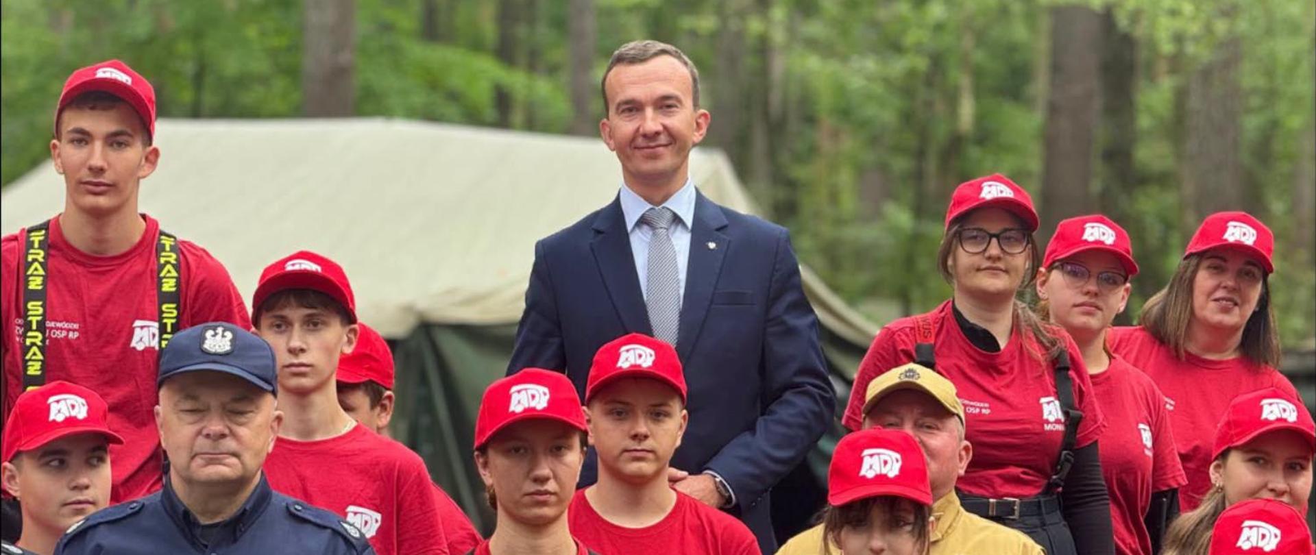 mężczyzna w garniturze, wicewojewoda, pozuje do zdjęcia z młodzieżą