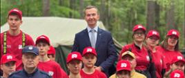 mężczyzna w garniturze, wicewojewoda, pozuje do zdjęcia z młodzieżą