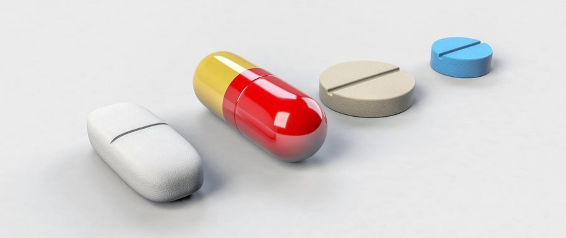 Zdjęcie przedstawia cztery tabletki, które znajdują się na białym tle.