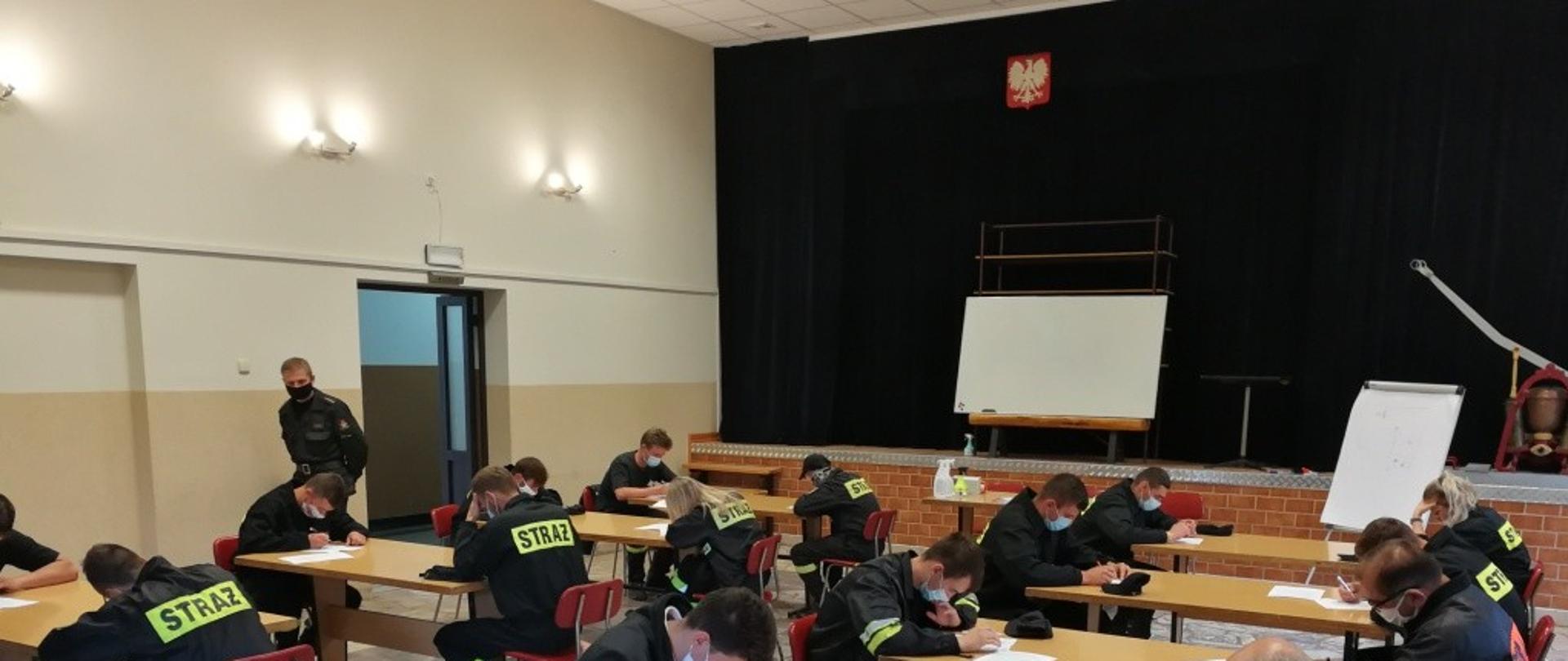 Grupa strażaków z jednostek OSP na egzaminie podczas kursu podstawowego.