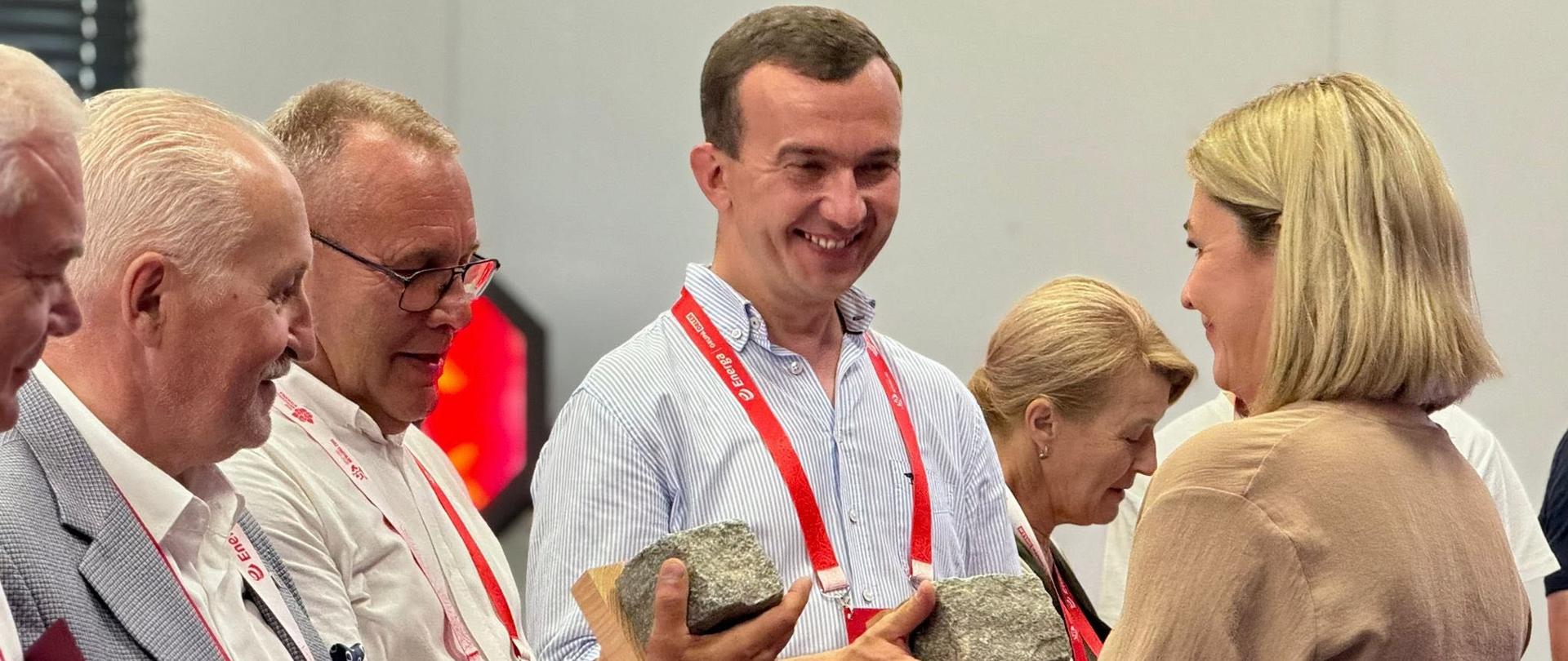 Kilka osób wręcza kobiecie statuetkę 