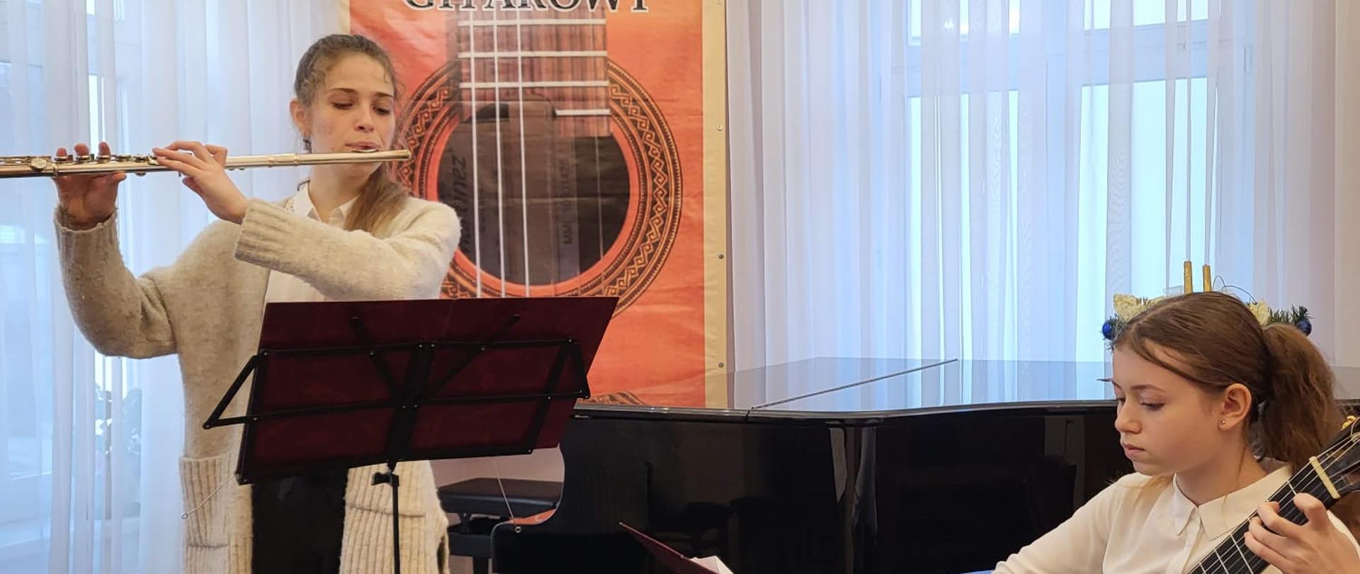 Zdjęcie przedstawia flecistkę wraz z gitarzystką podczas styczniowego konkursu kolędowego gitarzystów. 