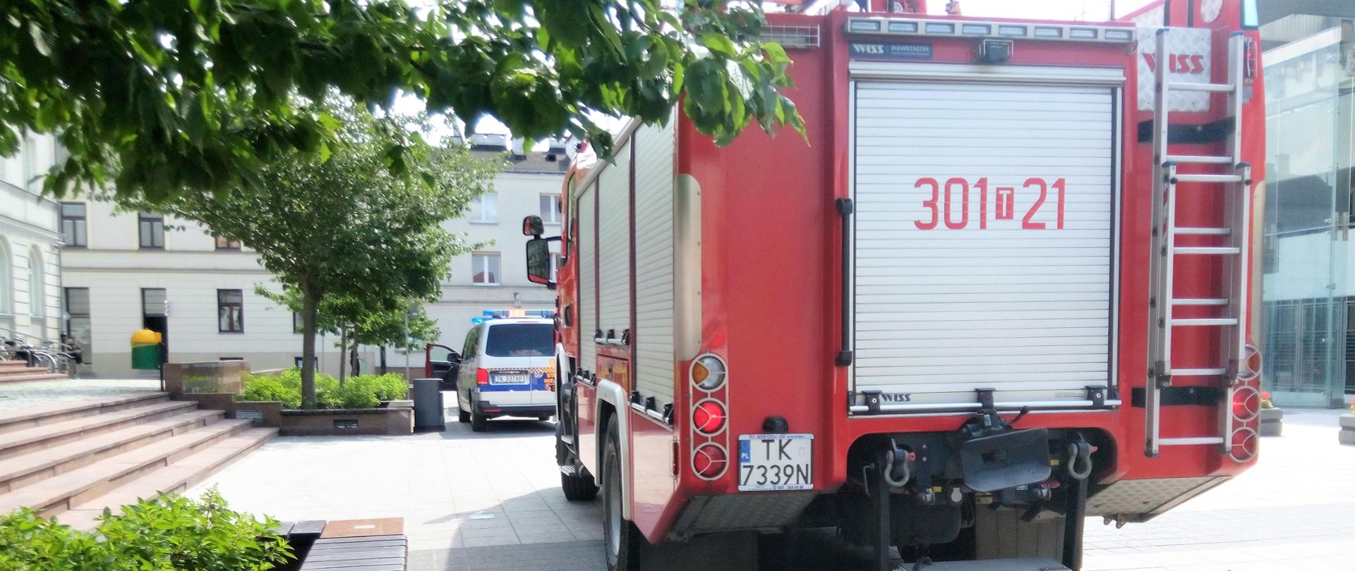 Na zdjęciu pokazane zostało miejsce przed wejściem do ratusza. Przy schodach wejściowych zaparkował samochód pożarniczy i radiowóz Straży Miejskiej.