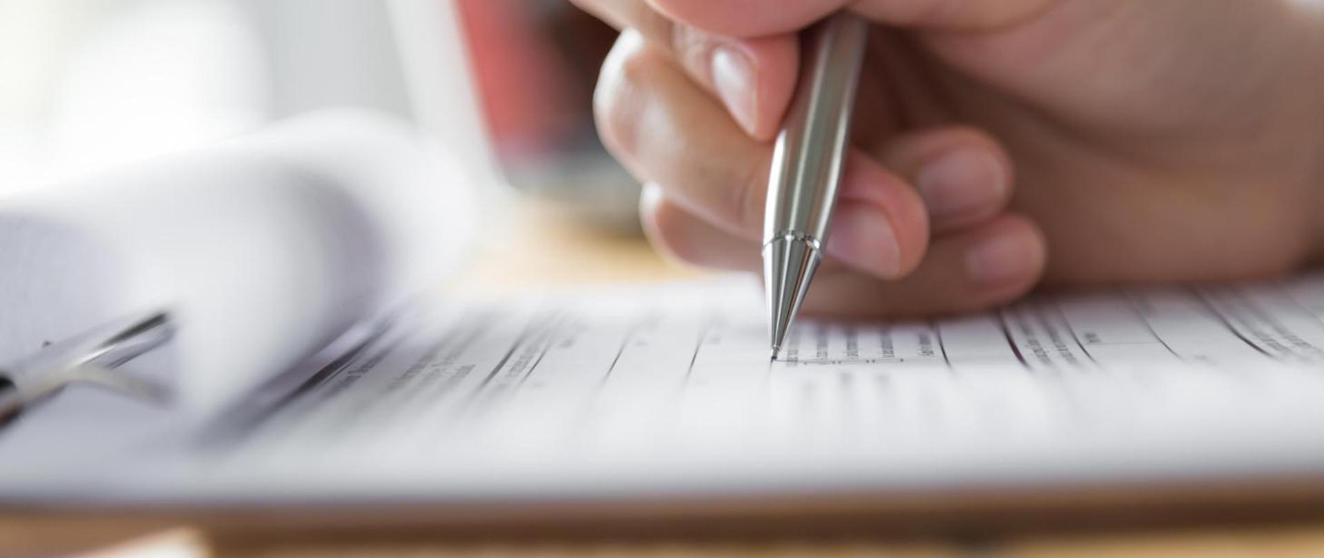 ręka trzymająca długopis