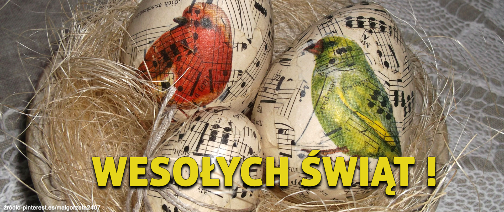 Na zdjęciu widać stół przykryty obrusem, na nim stoi koszyk z sianem a w nim trzy jajka - pisanki. Na jajkach namalowano czarne nuty na pięcioliniach a na dwóch jajkach dodatkowo kolorowe ptaki.