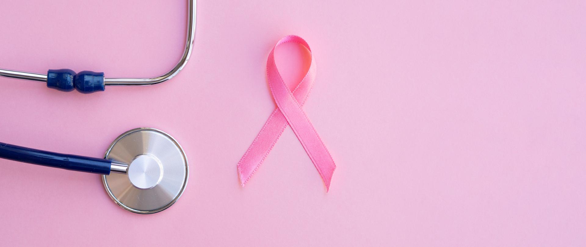 Zdjęcie przedstawia stetoskop i różową wstążkę, przedmioty, które nawiązują do badań profilaktycznych w kierunku nowotworów piersi.