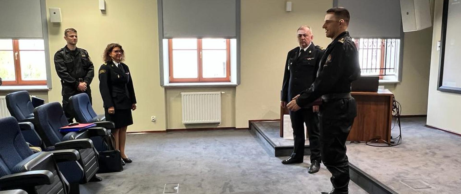 Na zdjęciu stoją brygadier Roman Krzywiec - komendant Miejski PSP m.st. Warszawy, brygadier Tomasz Jonio Naczelnik Wydziału Operacyjno-Szkoleniowego, młodszy brygadier Anna Zielińska Naczelnik Wydziału Kadrowego oraz starszy kapitan Bartosz Bajorek Zastępca Naczelnika Wydziału Operacyjno-Szkoleniowego.