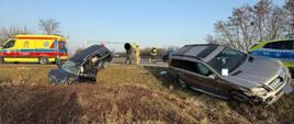 Dwa uszkodzone samochody w rowie, po lewej karetka