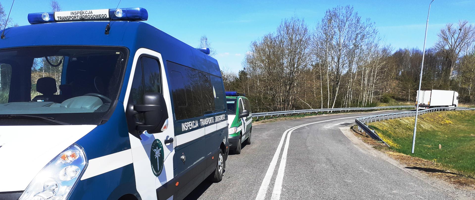 Kontrola inspektorów zachodniopomorskiej ITD na drodze krajowej nr 10. Na pierwszym planie, po lewej, inspekcyjny furgon, za nim inny radiowóz. W tle, po prawej zespół pojazdów.