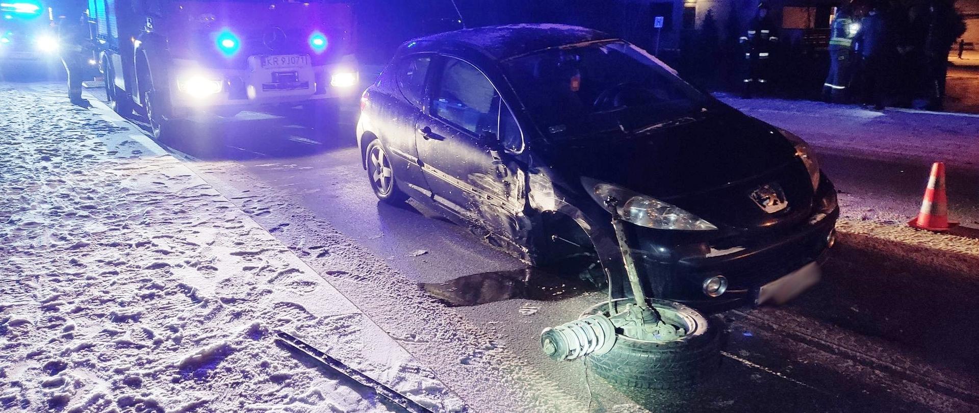 Uszkodzony samochód na drodze a za nim samochód pożarniczy