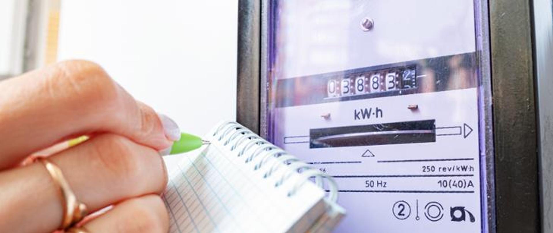 osoba spisuje liczby z miernika