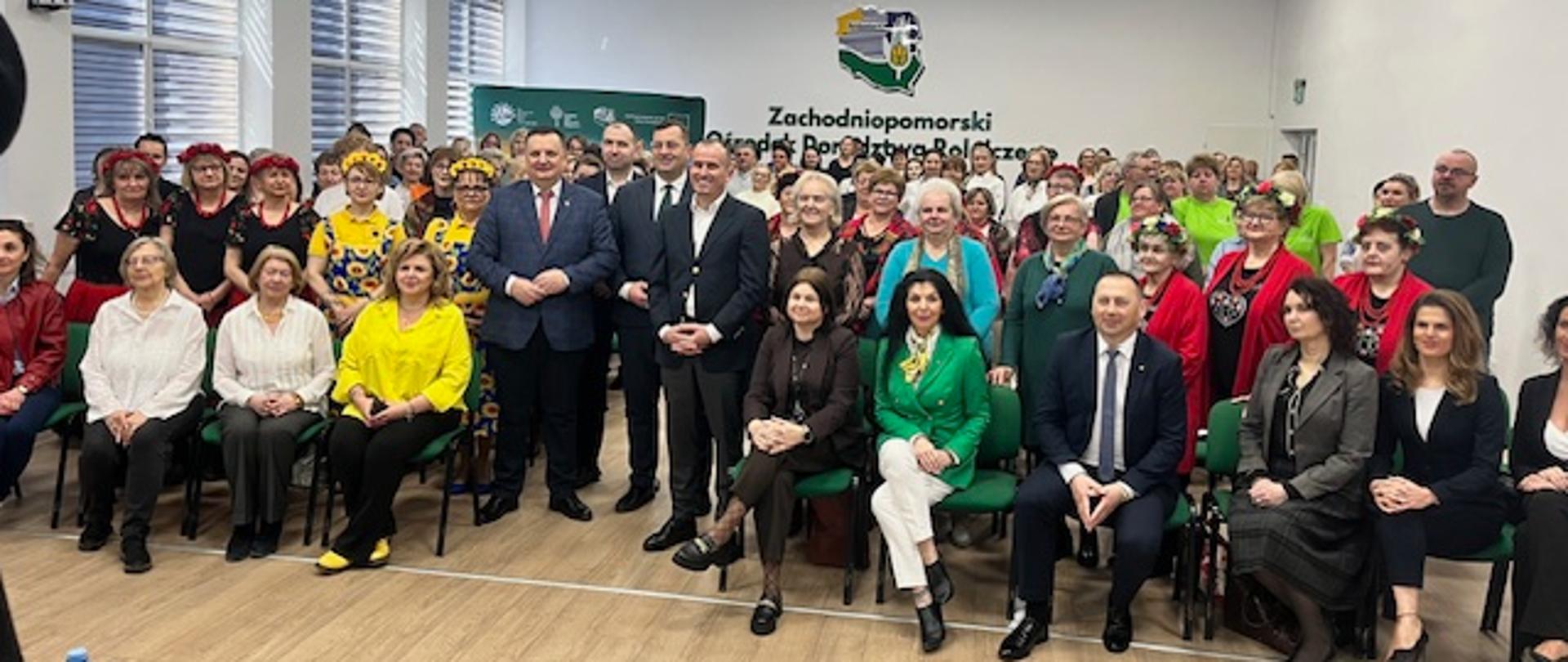 Minister Rolnictwa i Rozwoju Wsi Stefan Krajewski oraz Anna Kusy-Łowicka na zdjęciu grupowym podczas wydarzenia Dziedzictwo kulinarne regionu w praktyce KGW 18 marca 2026, obok uczestniczek Kół Gospodyń Wiejskich podczas szkolenia KGW