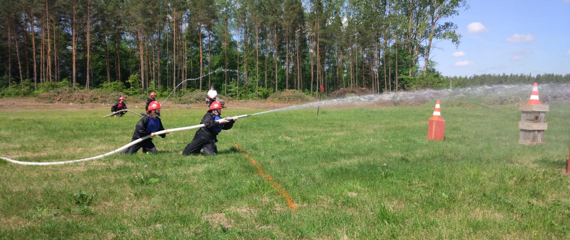 Rywalizacja drużyn pożarniczych na Gminnych zawodach sportowo-pożarniczych w konkurencji: "ćwiczenie bojowe". Drużyna żeńska OSP Ogrodniki