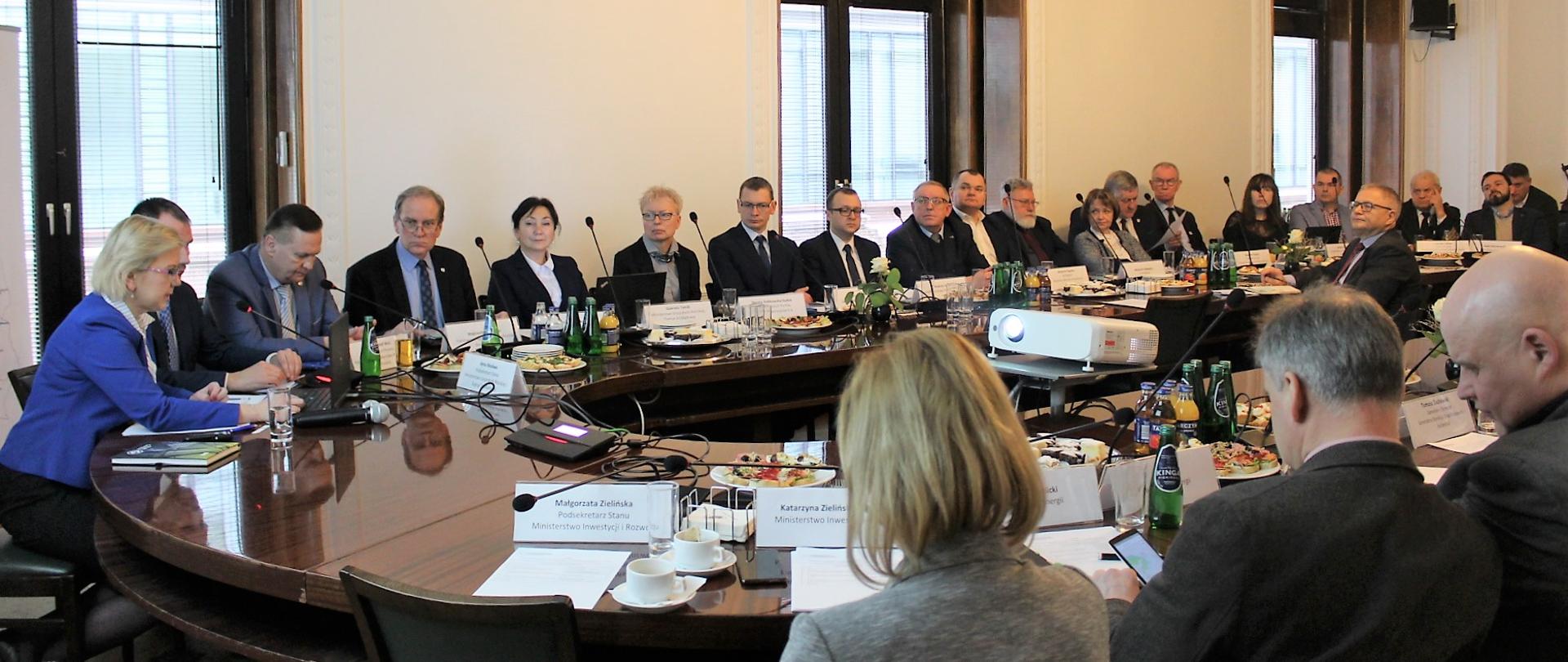 Minister Anna Moskwa przy stole z uczestnikami spotkania