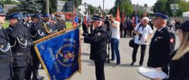 Marszałek Województwa Świętokrzyskiego przypina złoty znak związku ZOSP RP do sztandaru OSP Skarżysko-Kamienna