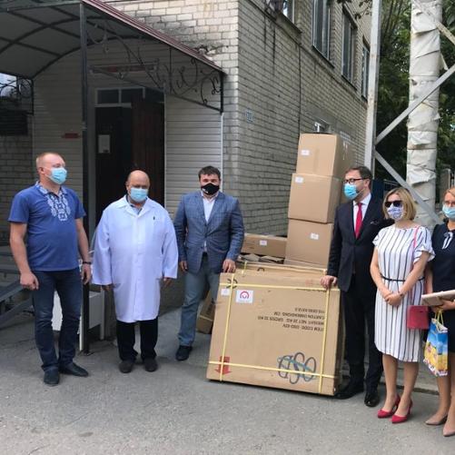 grupa osób stoi przed budynkiem.