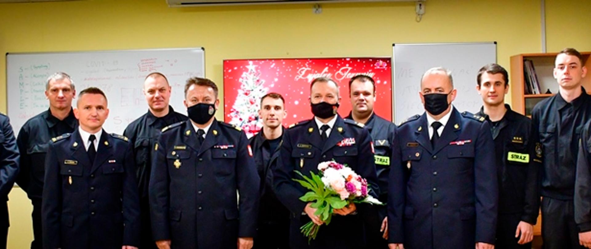 Wspólne zdjęcie funkcjonariuszy i Komendantów Państwowej Straży Pożarnej w siedzibie Jednostki Ratowniczo-Gaśniczej numer 9 Komendy Miejskiej Państwowej Straży Pożarnej miasta stołecznego Warszawy.