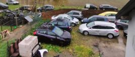 Widok z góry na odpady w postaci uszkodzonych pojazdów, zdemontowanych części i zużytych opon zgromadzone na posesji