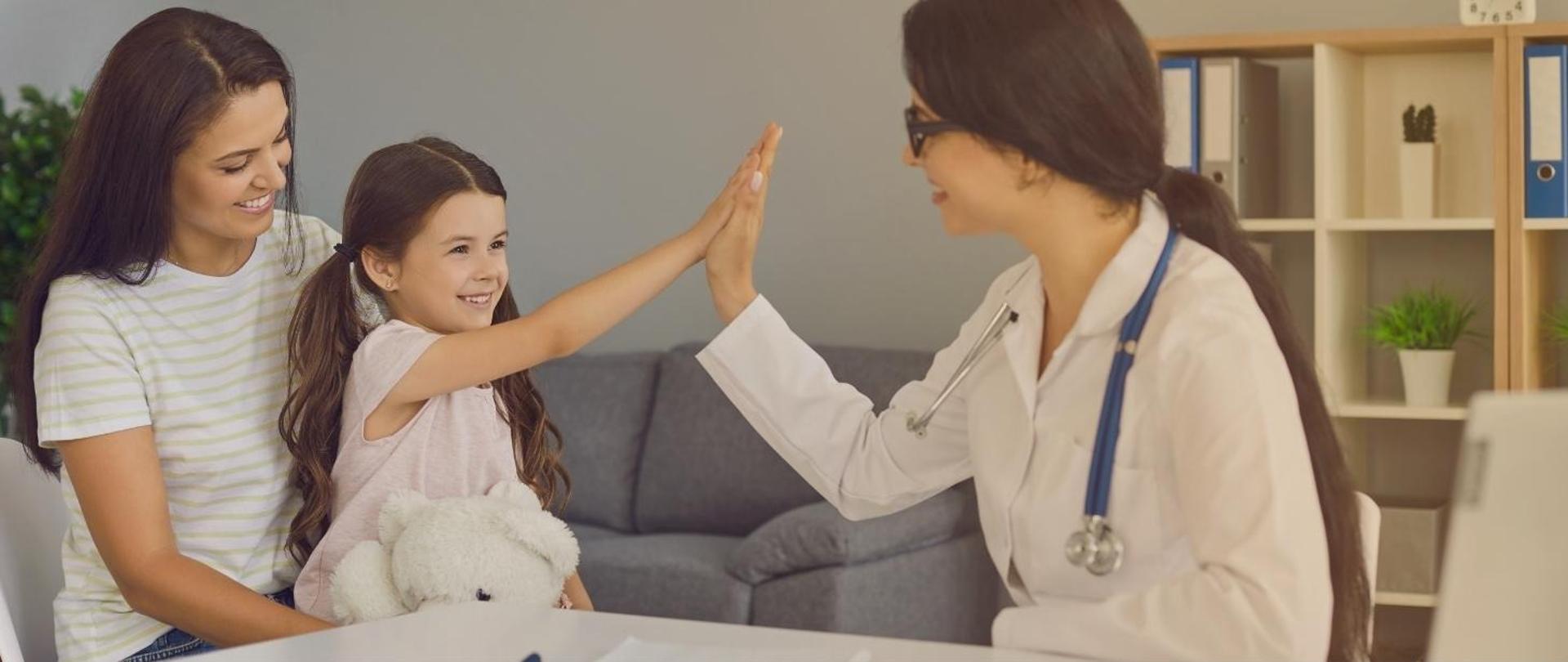 Na zdjęciu widoczna jest lekarka, która przyjmuje w gabinecie matkę z córką.