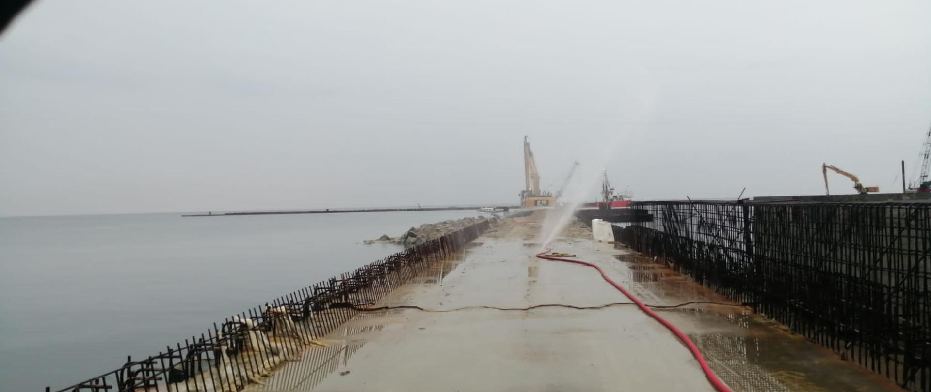 Widok na rozwiniętą linię gaśniczą a falochronie.